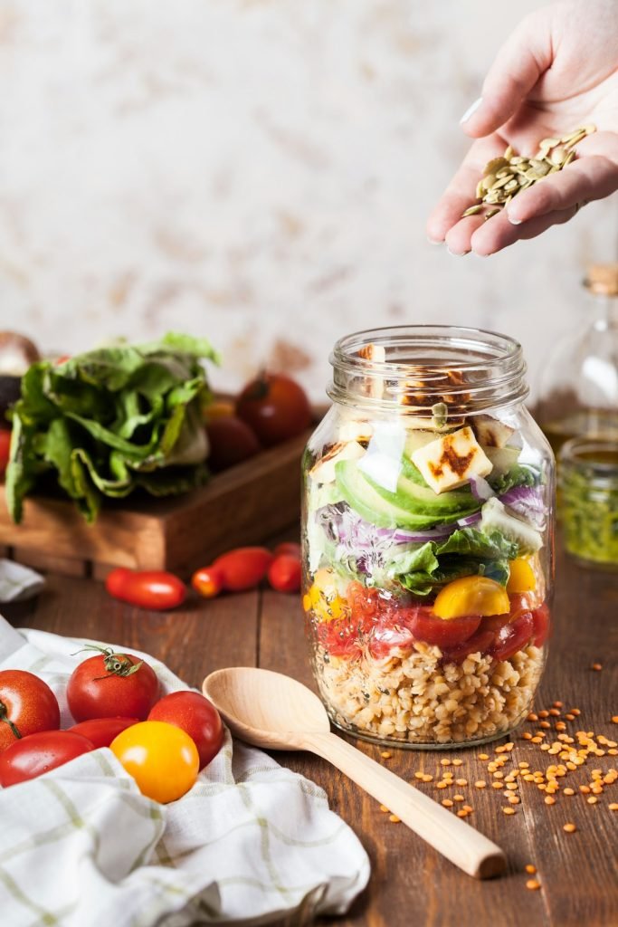 person-holding-brown-grains-usfie5yc7py Lentil salad with fried cheese in a jar